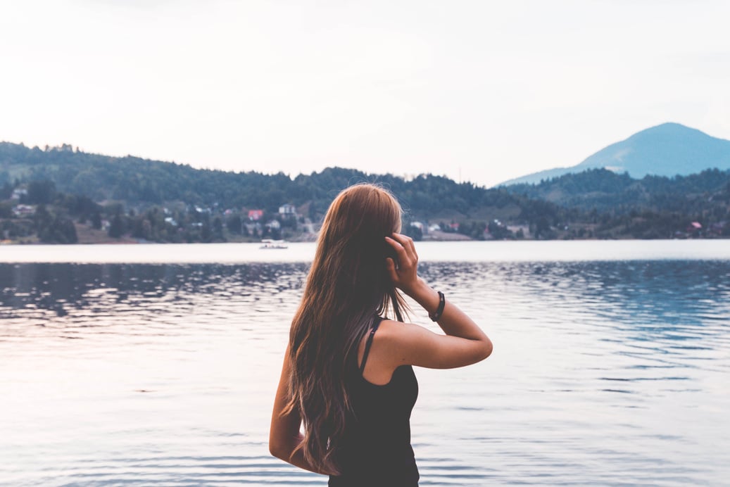 Woman Standing Near Calm Body Of Water