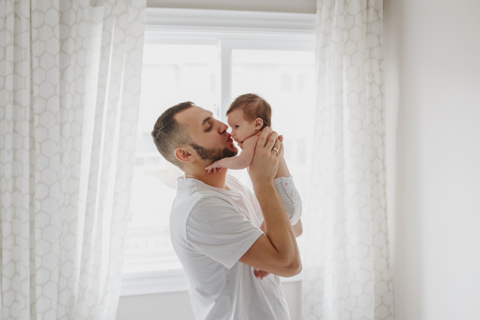 Father Kissing Newborn Baby